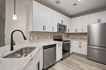 a kitchen with white cabinets and stainless steel appliances